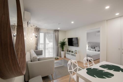 a white living room with a bed and a couch at "Comfort Stay" - Juodkrante in Juodkrantė