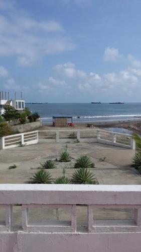 a bench in front of a beach with the ocean at Suites Sonikikos in Ballenita