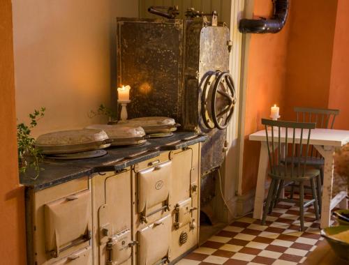 an old stove in a room with a table and candles at Kastellet Bed & Breakfast in Vaxholm