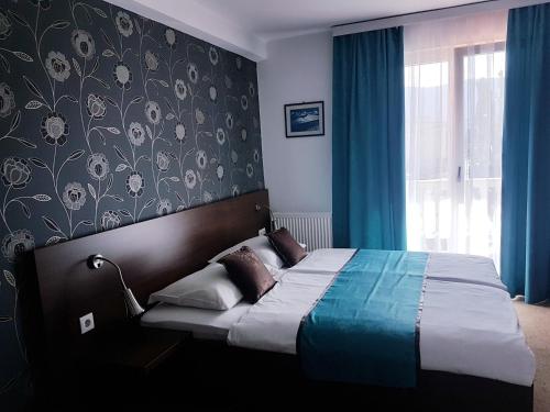 Schlafzimmer mit einem großen Bett und blauen Vorhängen in der Unterkunft Ahar in Sarajevo