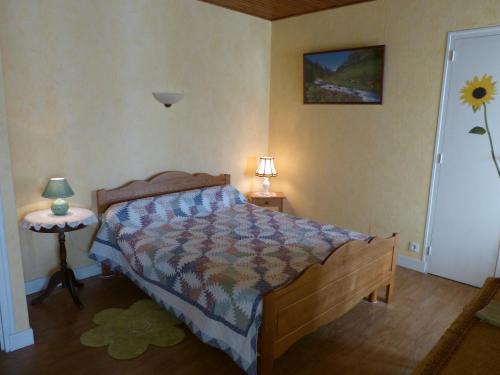 1 dormitorio con 1 cama y 1 mesa con lámpara en Chambres d'Hôtes La Plantade en La Barthe-de-Neste