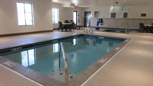 a large swimming pool in a room with tables and chairs at Comfort Inn & Suites Boise Airport in Boise
