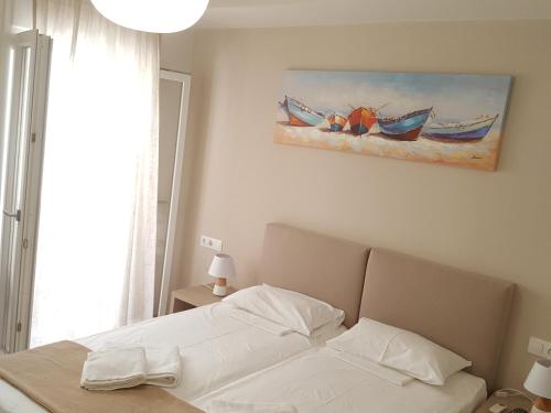 a bedroom with a bed and a painting on the wall at Minimalistic Studio Apartments in Heraklio Town