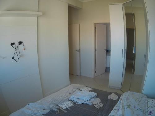 Habitación con cama con ropa en el suelo en Cobertura Em Canasvieiras, en Florianópolis