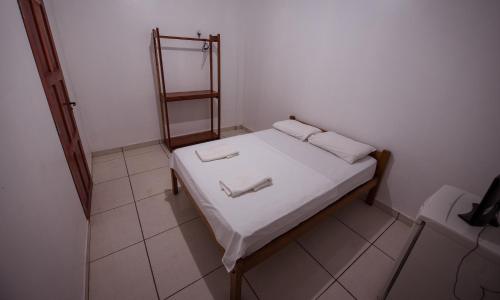 a small bedroom with a bed with two towels on it at Hotel Holliday in Macapá