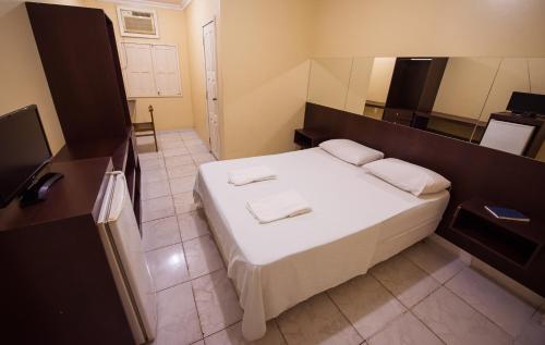 a bedroom with a bed with two towels on it at Hotel Holliday in Macapá