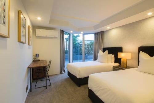 a hotel room with two beds and a window at Infinity Collection-Queenstown Luxury House in Queenstown