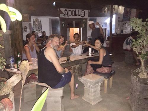 a group of people sitting at a table in a bar at Apollo Hostel in Lovina