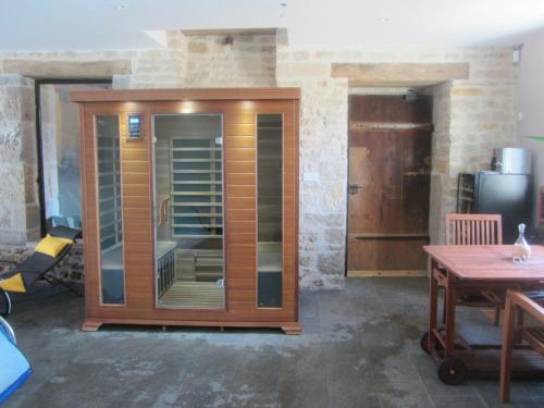a large wooden cabinet in a room with a table at Le relais des deux tours in Brémondans