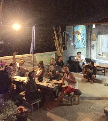 a group of people sitting at tables in a room at Apollo Hostel in Lovina