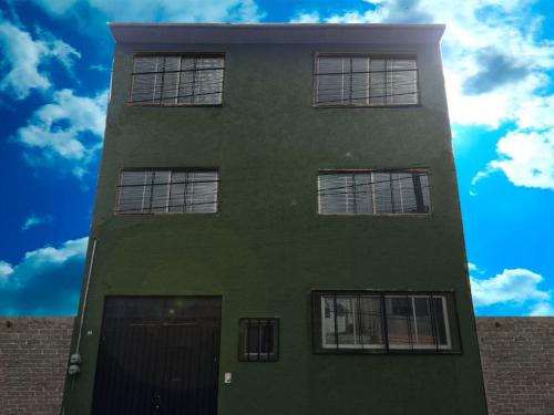 a green building with windows and a blue sky at Guest Green in Ciudad Nezahualcóyotl