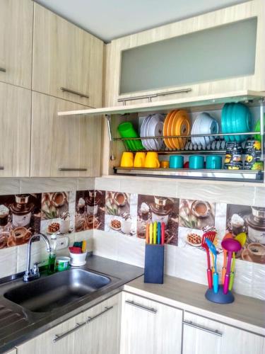 a kitchen with a sink and some cups and utensils at PeñalisaKapoSalSar in Girardot