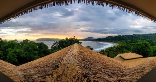 a view of the ocean from a straw hut at Nammbú Beach Front Bungalows in Sámara