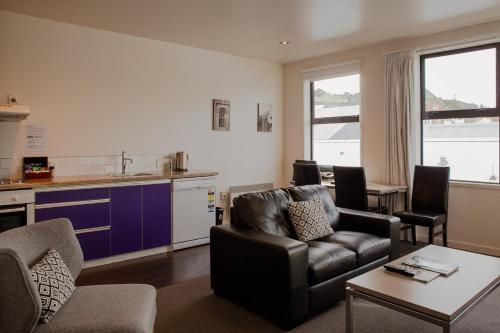 a living room with a couch and a table at 315 Euro Motel and Serviced Apartments in Dunedin