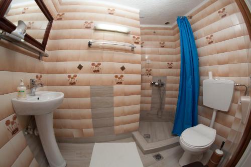 uma casa de banho com um WC, um lavatório e um chuveiro em Delfini em Kallithea Halkidikis