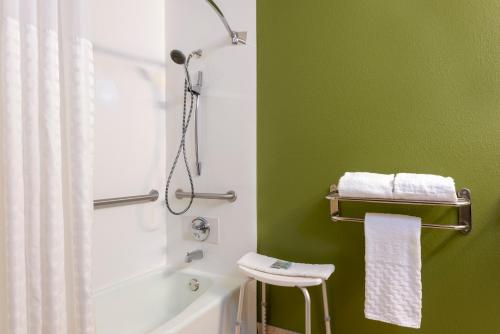 uma casa de banho verde com um chuveiro e uma banheira branca em Best Western Dutch Valley Inn em New Philadelphia