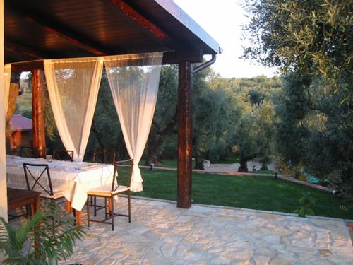 a patio with a table and chairs under a pavilion at I Giardini Di Margius in Itri