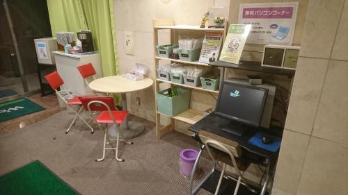 a room with a table and a tv and chairs at Hotel Togane Hills in Tōganemachi