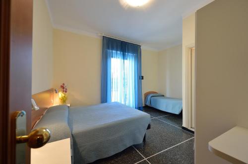 a hotel room with a bed and a window at Hotel Guya in Varazze