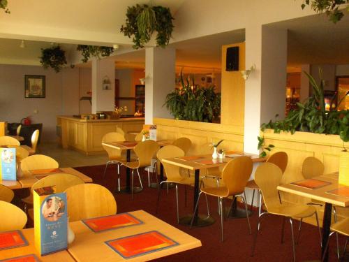 um restaurante com mesas e cadeiras e um balcão em Stay Inn Manchester em Manchester