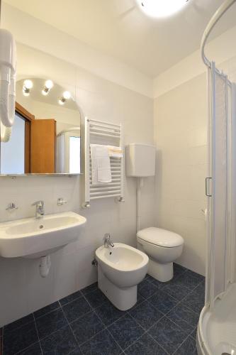 a bathroom with a sink and a toilet and a mirror at Hotel Guya in Varazze
