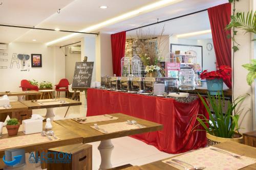 a restaurant with red curtains and tables and a counter at Rock Hotel in Krukah