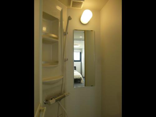 eine Badezimmertür mit Spiegel und Licht in der Unterkunft Nagoya Motoyama House B in Nagoya