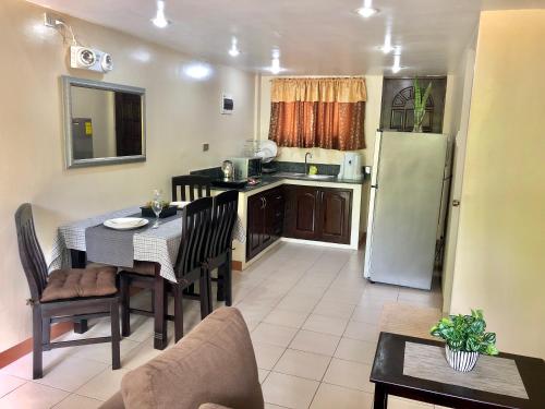 a small kitchen with a table and a refrigerator at Pal-Watson Apartments in Mactan
