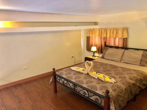 a bedroom with a bed with a pair of shoes on it at Pal-Watson Apartments in Mactan
