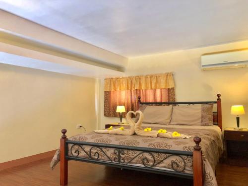 a bedroom with a bed with a swan on it at Pal-Watson Apartments in Mactan