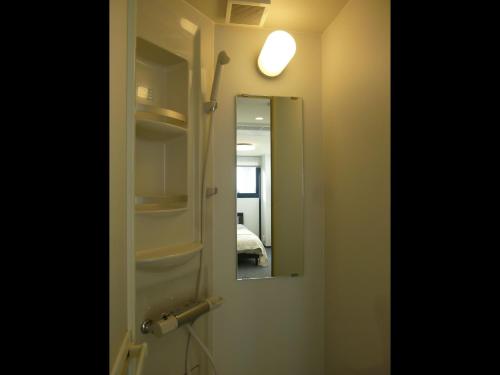 a bathroom door with a mirror and a light at Nagoya Motoyama House C in Nagoya