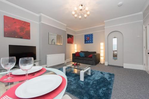 a living room with a table and two wine glasses at Sea Front Walk in Broadstairs