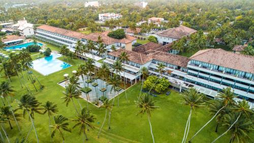 an aerial view of a resort with a pool and palm trees at The Blue Water - Geoffrey Bawa Heritage Resort Hotel in Wadduwa