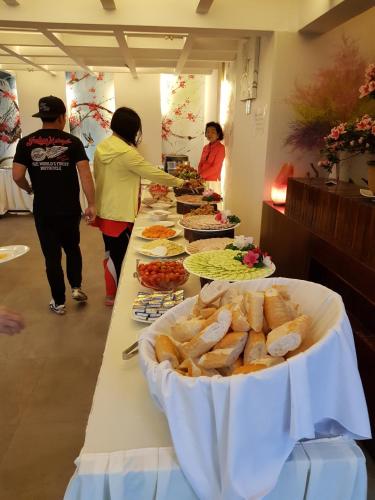 a group of people standing around a table with food at Melody Hotel in Da Lat