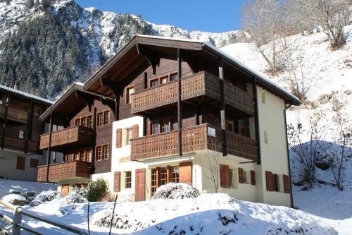 ein großes Gebäude mit Schnee auf dem Boden in der Unterkunft Arnika in Blatten bei Naters