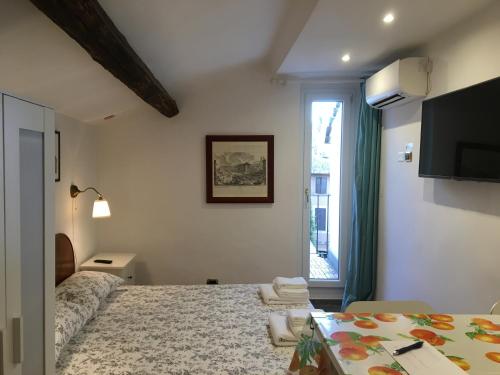 1 dormitorio con 1 cama, TV y ventana en M9 Pantheon Attic 11, en Roma