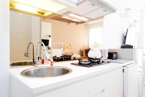 a kitchen with a sink and a counter top at Studio Signature Park Grande Apartment Near MT Haryono By Travelio in Jakarta