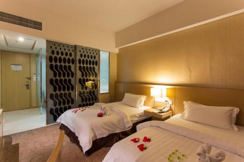 a hotel room with two beds with flowers on them at Metropolo, Langfang, Wanda Plaza-Ningyuan Park in Langfang