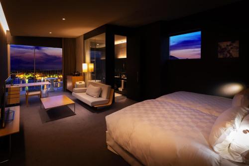 a bedroom with a bed and a living room with a balcony at Garden Terrace Nagasaki Hotels & Resorts in Nagasaki