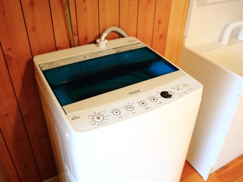 a washer and dryer in a corner of a kitchen at カモンイン 寿 in Izumi