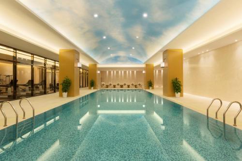 - une piscine dans un hôtel avec plafond dans l'établissement Wyndham Chongqing Yuelai, à Chongqing