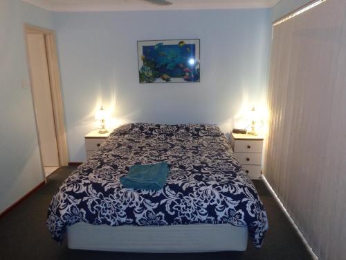 a bedroom with a bed with a blue and white blanket at Denison Waterfront in Port Denison