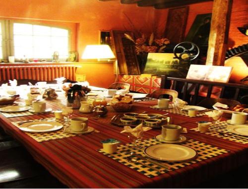 einen Tisch mit Tellern und Geschirr darüber in der Unterkunft Le Moulin Fleuri du Petit Appeville in Petit-Appeville