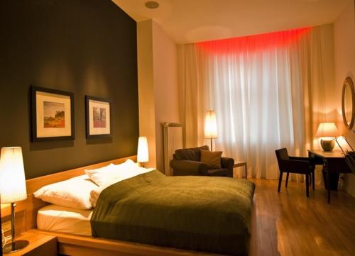 um quarto com uma cama, uma cadeira e uma secretária em Ivana Apart Hotel em Oradea