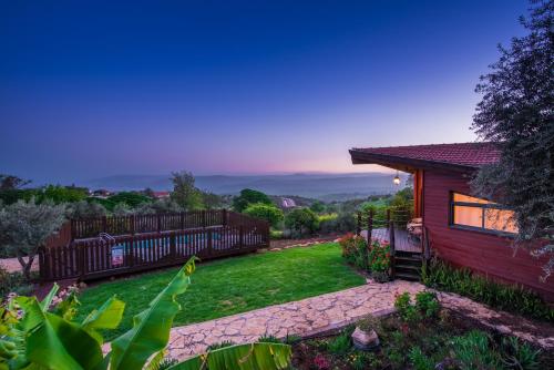 a home with a yard with a fence at Nof Tzameret Cabins in Kahal
