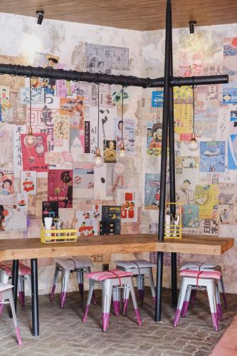 a table and stools in front of a wall with posters at Bali Ayu Hotel & Villas in Seminyak