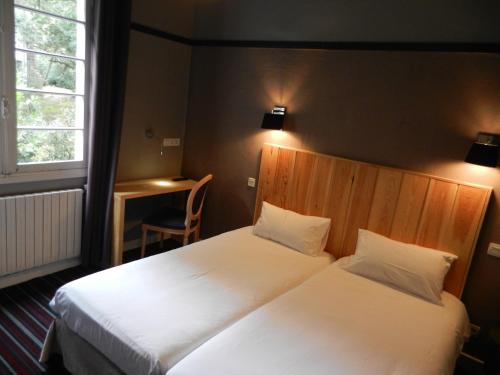 2 bedden in een hotelkamer met witte lakens bij Hôtel La Paloma in Hossegor