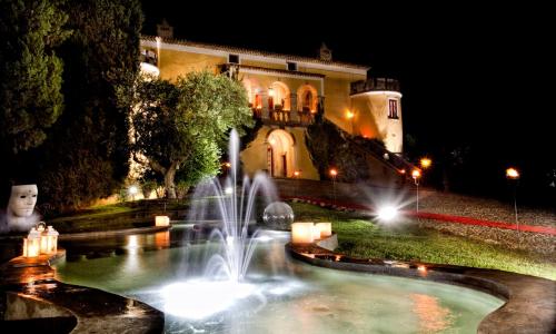 a fountain in front of a building at night at Castello di Serragiumenta in Firmo