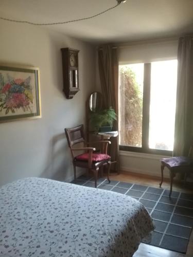 a bedroom with a bed and a window and a chair at Jardín de Hoz in Hoz de Jaca