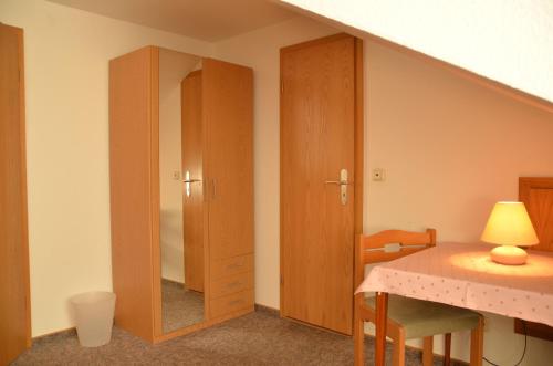 a room with a cabinet and a table with a lamp at Landhaus Braband in Cuxhaven